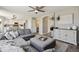 Spacious living room with an open floorplan, gray sectional sofa, white cabinets, and wood-look flooring at 1461 Hickory Ct, Erie, CO 80516