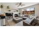 Bright living room features a fireplace, ceiling fan, plush gray sectional, and large window overlooking the backyard at 1461 Hickory Ct, Erie, CO 80516