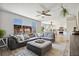 A roomy living room boasts a gray sectional sofa, an open floor plan, and a view of the kitchen and backyard at 1461 Hickory Ct, Erie, CO 80516