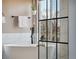 Stylish soaking tub with matte black hardware and view out of the window in the main bathroom at 1461 Hickory Ct, Erie, CO 80516