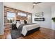 A lovely main bedroom with a faux brick wall, electric fireplace, and hardwood floors at 1461 Hickory Ct, Erie, CO 80516