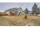 Large backyard with mature trees, garden pond feature, patio, and lush lawn at 8208 Tabor Ct, Arvada, CO 80005