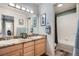 Updated bathroom with a double sink vanity, granite countertops, and tiled shower/tub combo at 8208 Tabor Ct, Arvada, CO 80005