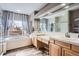 Bright bathroom featuring double sinks, soaking tub, separate glass shower, and wood-look floors at 8208 Tabor Ct, Arvada, CO 80005