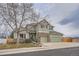 Charming two-story home in green and brick with a landscaped yard and three car garage at 8208 Tabor Ct, Arvada, CO 80005