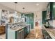 Stylish kitchen featuring green cabinetry, granite countertops, a breakfast bar, and stainless appliances at 8208 Tabor Ct, Arvada, CO 80005