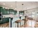 Charming kitchen with green cabinetry, granite countertops, stainless steel appliances, and breakfast bar at 8208 Tabor Ct, Arvada, CO 80005