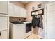 Functional laundry room with washer, dryer, storage cabinets, and convenient hanging space at 8208 Tabor Ct, Arvada, CO 80005