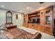 Cozy living room features a large, built-in wooden cabinet and plush brown leather sofa at 8208 Tabor Ct, Arvada, CO 80005