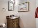 Stylish powder room with unique vanity, marble countertop, and ornate mirror at 8208 Tabor Ct, Arvada, CO 80005