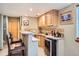 Basement wet bar with sleek counter, cabinets, wine cooler, and barstool seating at 8208 Tabor Ct, Arvada, CO 80005