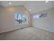 Well-lit room with neutral colors, vaulted ceiling, carpeted floors, and a window view at 2430 Ames St, Edgewater, CO 80214
