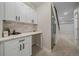 Clean butler's pantry featuring white cabinets, counter space, and access to the staircase at 2430 Ames St, Edgewater, CO 80214