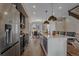 Modern kitchen featuring stainless steel appliances, a large island with seating, and hardwood floors at 2430 Ames St, Edgewater, CO 80214