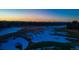 An aerial view of the golf course at dusk showing snow covering the green at 93 Glenmoor Dr, Englewood, CO 80113