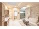 Bright bathroom featuring tiled floors, a glass shower, a soaking tub, and dual vanity sinks with stylish cabinetry at 93 Glenmoor Dr, Englewood, CO 80113