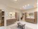 Bright bathroom featuring double vanities with wood cabinets, a skylight and a decorative gray bench at 93 Glenmoor Dr, Englewood, CO 80113