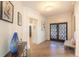 Welcoming foyer showcasing dark paneled double doors, wood floors, and decorative blue glass vase at 93 Glenmoor Dr, Englewood, CO 80113