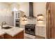 Elegant kitchen featuring a modern gas range, custom cabinets, marble counters, and a stylish chandelier at 93 Glenmoor Dr, Englewood, CO 80113