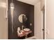 Stylish powder room featuring a unique sink, a porthole mirror, and a decorative light fixture at 93 Glenmoor Dr, Englewood, CO 80113