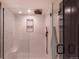 Sleek walk-in shower featuring white tile walls, a modern rain shower head, and black hardware at 93 Glenmoor Dr, Englewood, CO 80113