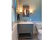Stylish bathroom with blue walls, decorative mirror and a gray vanity at 6585 W 84Th Way # 109, Arvada, CO 80003