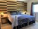 Comfortable bedroom with decorative wood accent wall and plush bedding at 6585 W 84Th Way # 109, Arvada, CO 80003
