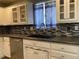 Kitchen features a stainless steel sink, mosaic backsplash, and white cabinets at 6585 W 84Th Way # 109, Arvada, CO 80003