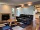 Spacious living room featuring a fireplace, hardwood floors, and a comfortable leather sofa at 6585 W 84Th Way # 109, Arvada, CO 80003