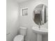 Powder bathroom with a floating sink, a round mirror, a toilet and a small window at 2046 S Holly St # 1, Denver, CO 80222
