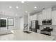 Bright kitchen features white cabinets, stainless steel appliances, large sink, and quartz countertops at 2046 S Holly St # 1, Denver, CO 80222