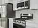 Updated Kitchen with stainless steel appliances, quartz countertops, and bright lighting at 2046 S Holly St # 1, Denver, CO 80222