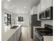 Open kitchen with an island, stainless steel appliances, light wood floors and bright light from a large window at 2046 S Holly St # 1, Denver, CO 80222