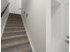 Carpeted staircase with a dark handrail, set against a clean white wall at 2046 S Holly St # 1, Denver, CO 80222