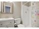 Compact bathroom featuring a white vanity, toilet, and a shower with floral curtain at 10711 Longs Way, Parker, CO 80138