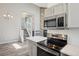 Modern kitchen with stainless steel appliances and stairs to the second floor at 10711 Longs Way, Parker, CO 80138