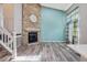 Bright living room featuring a stone fireplace, light hardwood floors, and large windows with decorative curtains at 10711 Longs Way, Parker, CO 80138