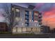 Modern condo building with a colorful sunset, showcasing private balconies at 2374 S University Blvd # 402, Denver, CO 80210