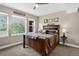 Comfortable bedroom with rustic wood bed frame, natural light from large windows and Evergreen themed decor at 31189 Manitoba Dr, Evergreen, CO 80439