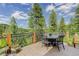 Outdoor dining area with a table and chairs, offering a scenic view of the lush greenery at 31189 Manitoba Dr, Evergreen, CO 80439