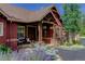Charming home entrance with stone pillars and wooden beamed porch with potted plants at 31189 Manitoba Dr, Evergreen, CO 80439