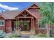 Charming home entrance featuring a covered porch, stone accents, and manicured landscaping at 31189 Manitoba Dr, Evergreen, CO 80439