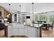 Bright kitchen features a spacious island, modern appliances, and scenic views from the surrounding windows at 31189 Manitoba Dr, Evergreen, CO 80439