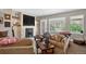 Cozy living room featuring a stone fireplace with floating shelves and a large window showcasing a view of nature at 31189 Manitoba Dr, Evergreen, CO 80439