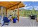Spacious outdoor deck with a wooden pergola, seating, and a scenic mountain view in the background at 31189 Manitoba Dr, Evergreen, CO 80439