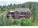 A beautiful home set within a canopy of trees features multiple decks for outdoor living at 31189 Manitoba Dr, Evergreen, CO 80439