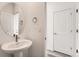 Clean half bathroom with a vessel sink, chrome faucet and modern fixtures near a hallway and doorway at 1224 S Algonquian St, Aurora, CO 80018