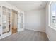 Bedroom features French doors, a large window, and neutral carpeting with light gray walls at 1300 Sienna Peak Cir, Erie, CO 80516