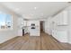 Open-concept kitchen with white cabinets, stainless steel appliances, an island, and wood laminate flooring at 1300 Sienna Peak Cir, Erie, CO 80516
