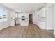 Open-concept kitchen with white cabinets, stainless steel appliances, an island, and wood laminate flooring at 1300 Sienna Peak Cir, Erie, CO 80516